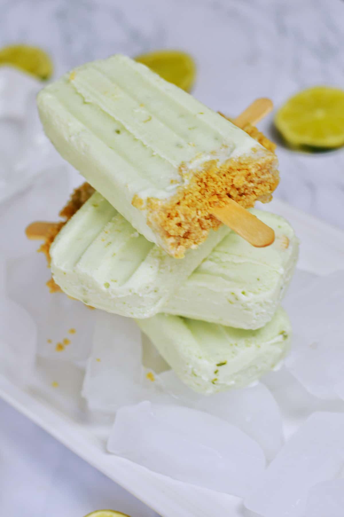 stack of 3 key lime popsicles on ice.