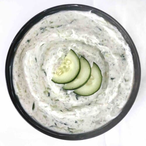 bowl of tzatziki with cucumbers on top