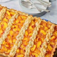 Full sheet pan of peach slab pie with braided top crust