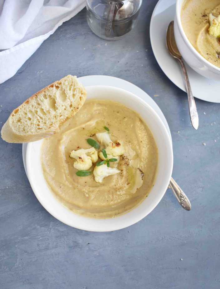 cauliflower soup with slice of bread on side