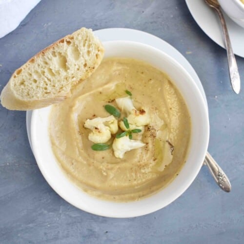 bowl of cauliflower soup with bread on side