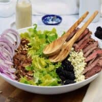 large white bowl with ingredients for steak salad