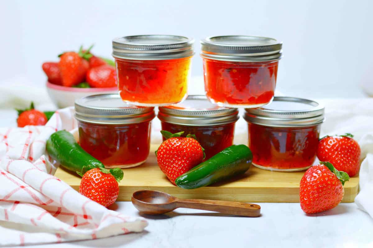 Stacked jars of strawberry jalapeno jam.
