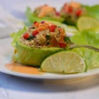 fresh avocado stuffed with quinoa salad and habanero sauce on white plate