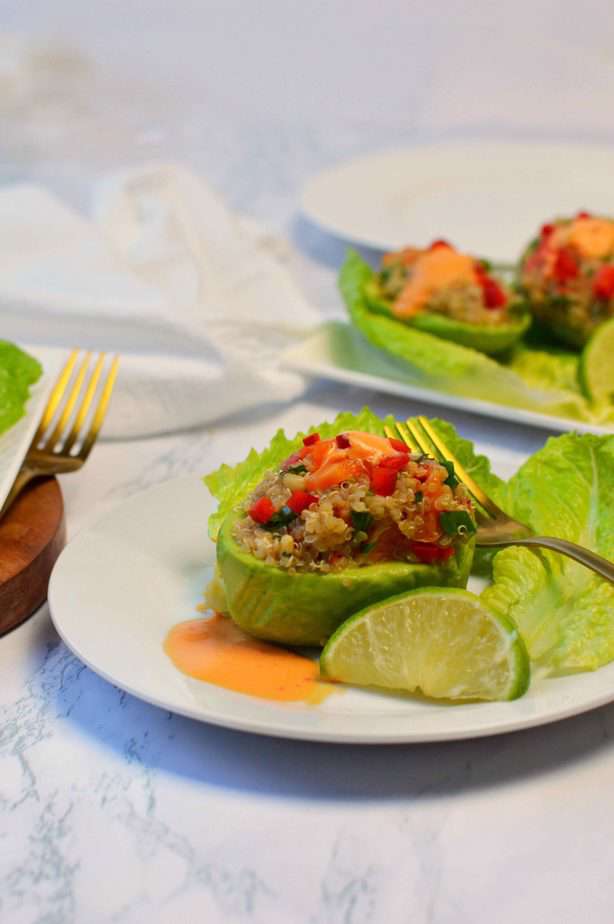 fresh avocado stuffed with quinoa salad on white platter