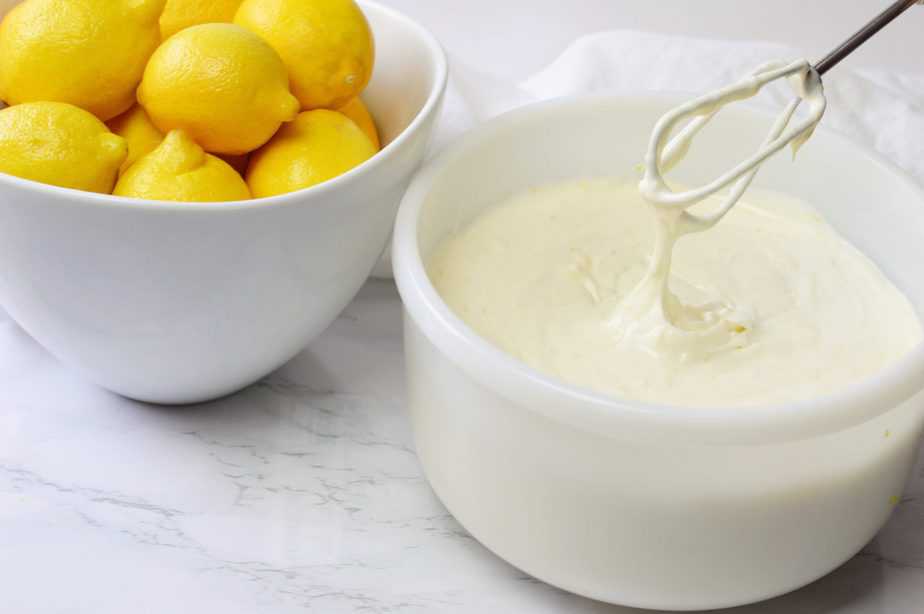 white bowl of lemon cheesecake filling with beater