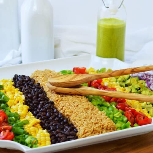 white platter with rows of vegetables for cowboy rice salad