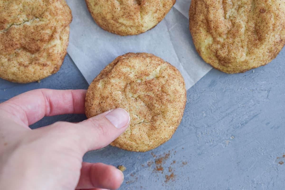hand picking up snickerdoodle cookie. 