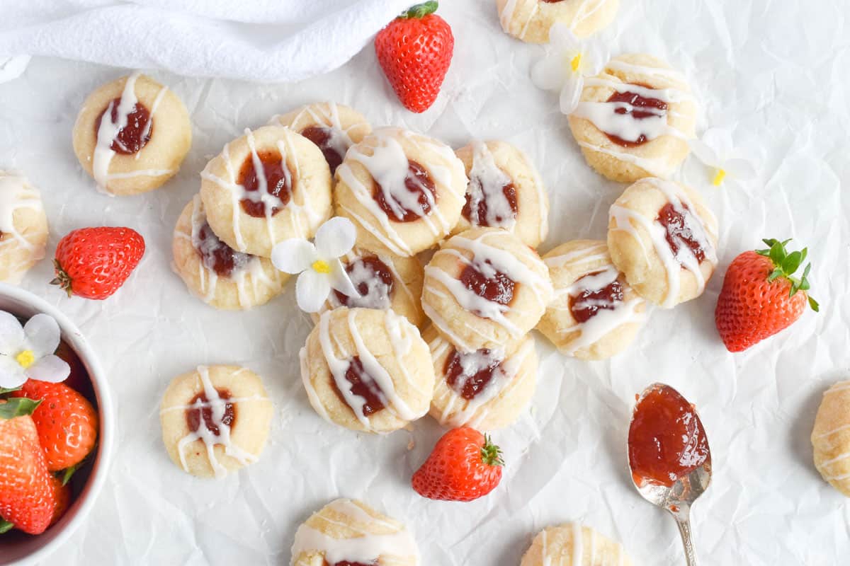 pile of strawberry shortbread cookies with strawberries. 