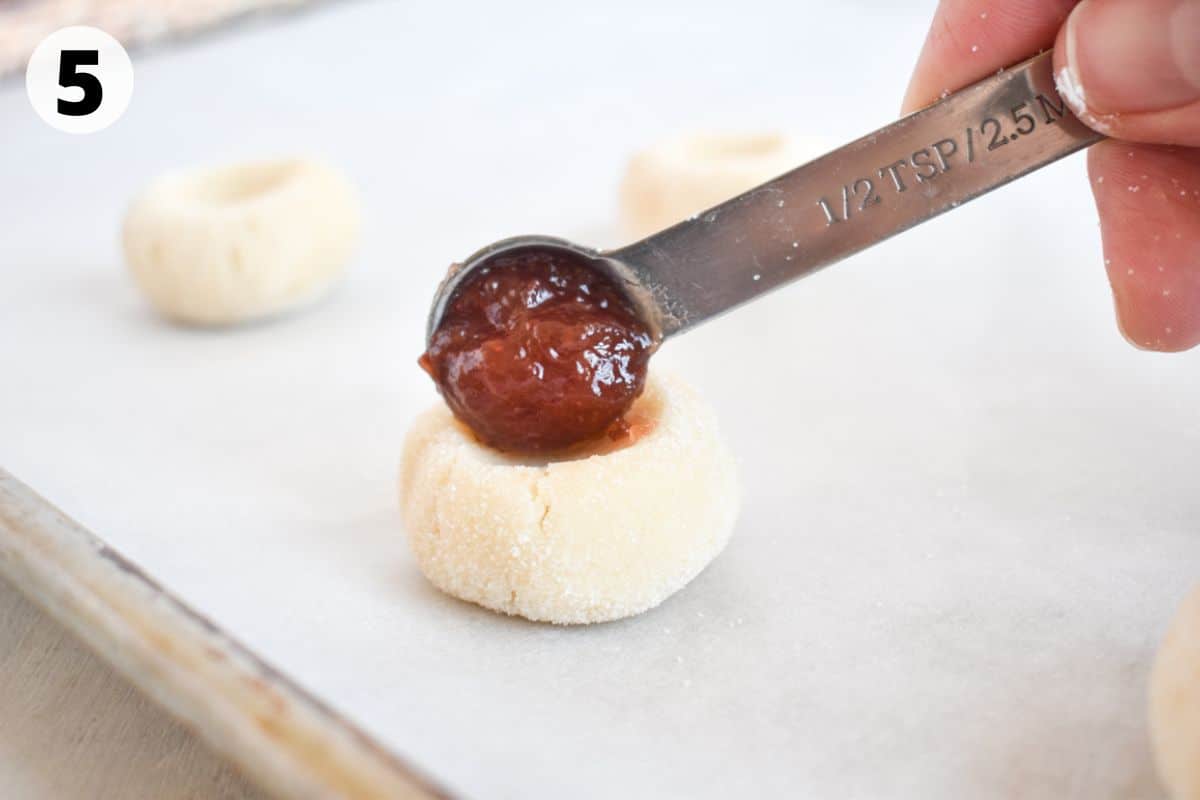 jam being added to shortbread cookies. 