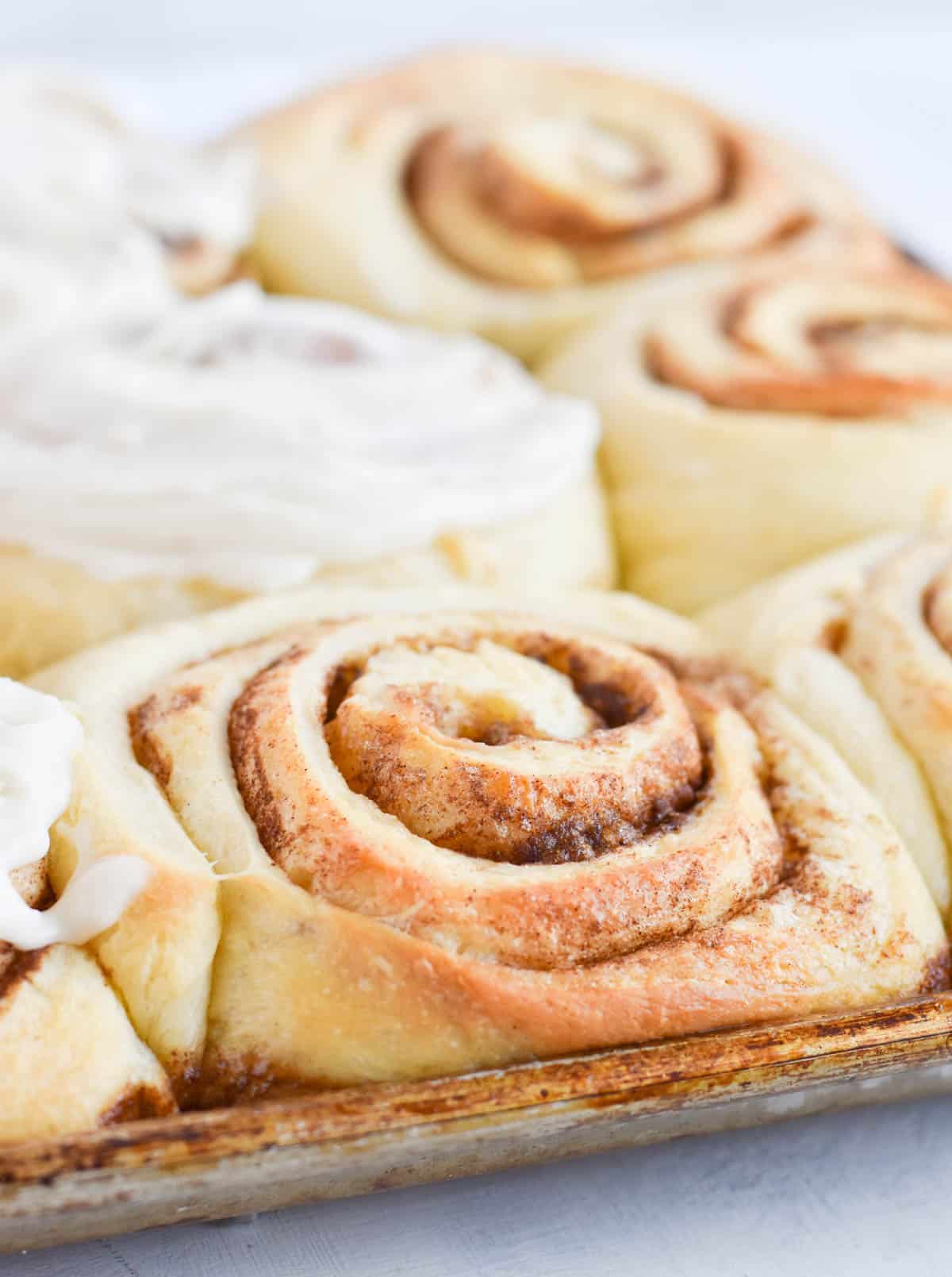 close up of unfrosted cinnamon roll in pan. 
