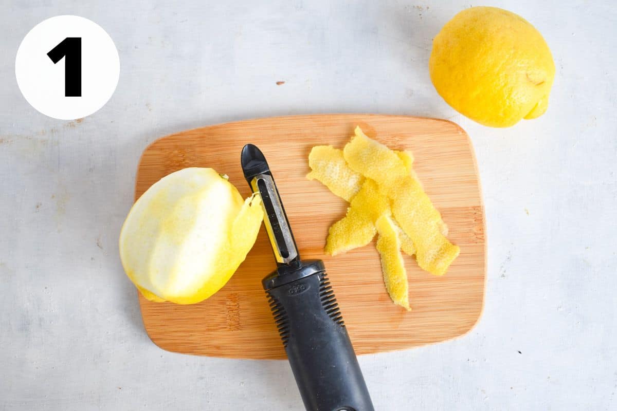 lemon being peeled on cutting board.