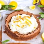 chocolate cake with cream on top on wooden board.
