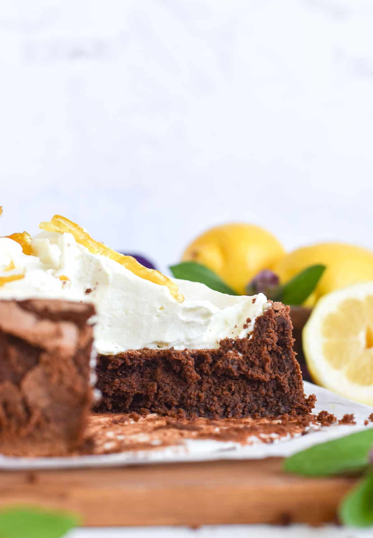 sliced open chocolate cake with white chocolate lemon cream on top.