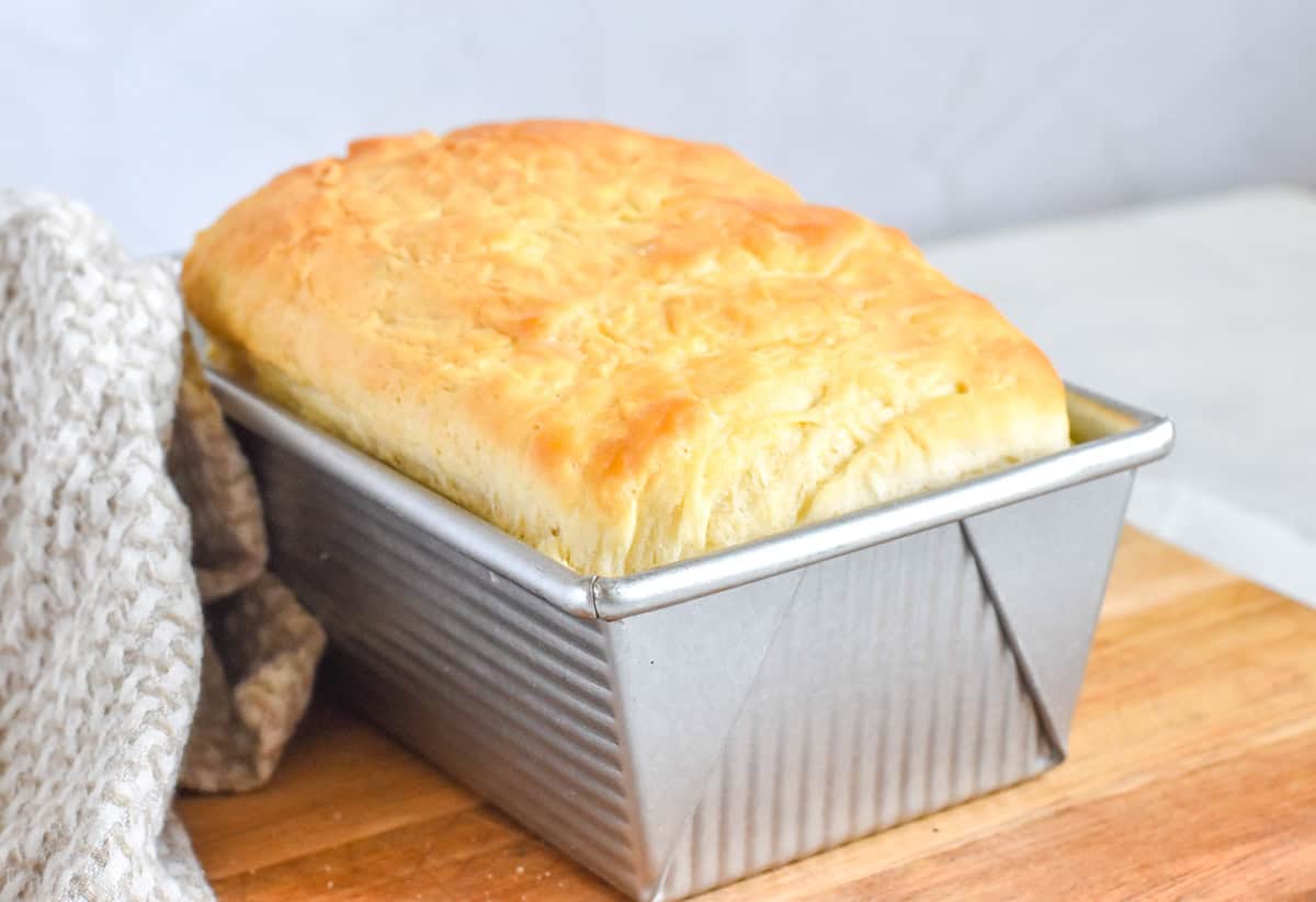 baked sourdough loaf in metal bread pan.