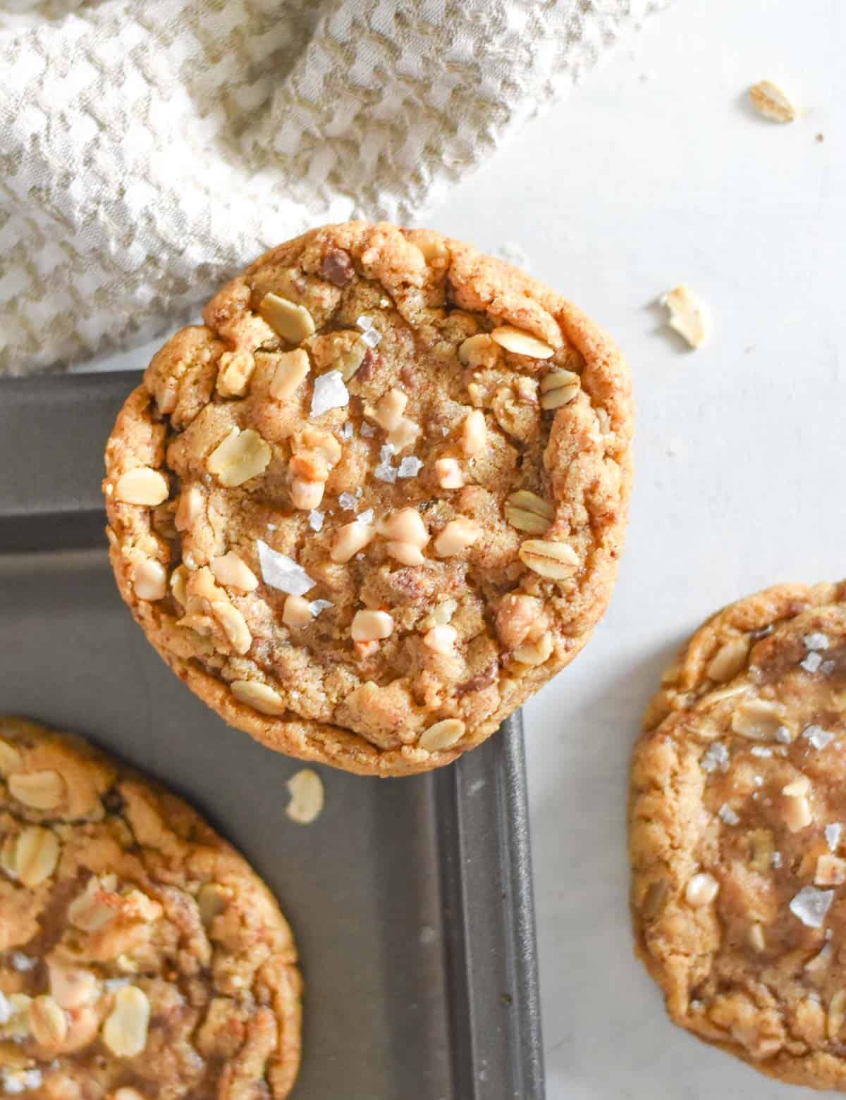 oatmeal cookie sitting on corner of baking sheet. 