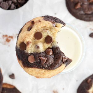 marble cookie with bite out missing on glass of milk.