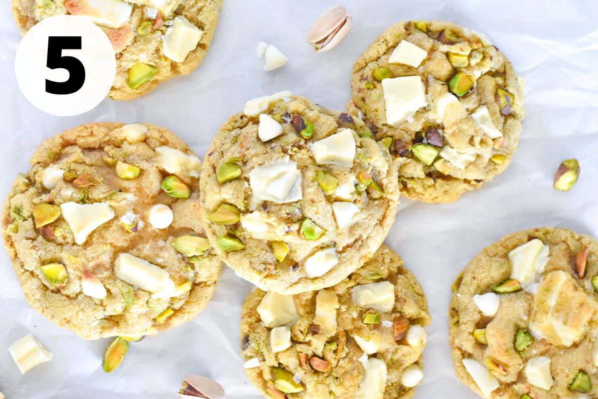 pistachio white chocolate cookies baked and on white parchment paper.