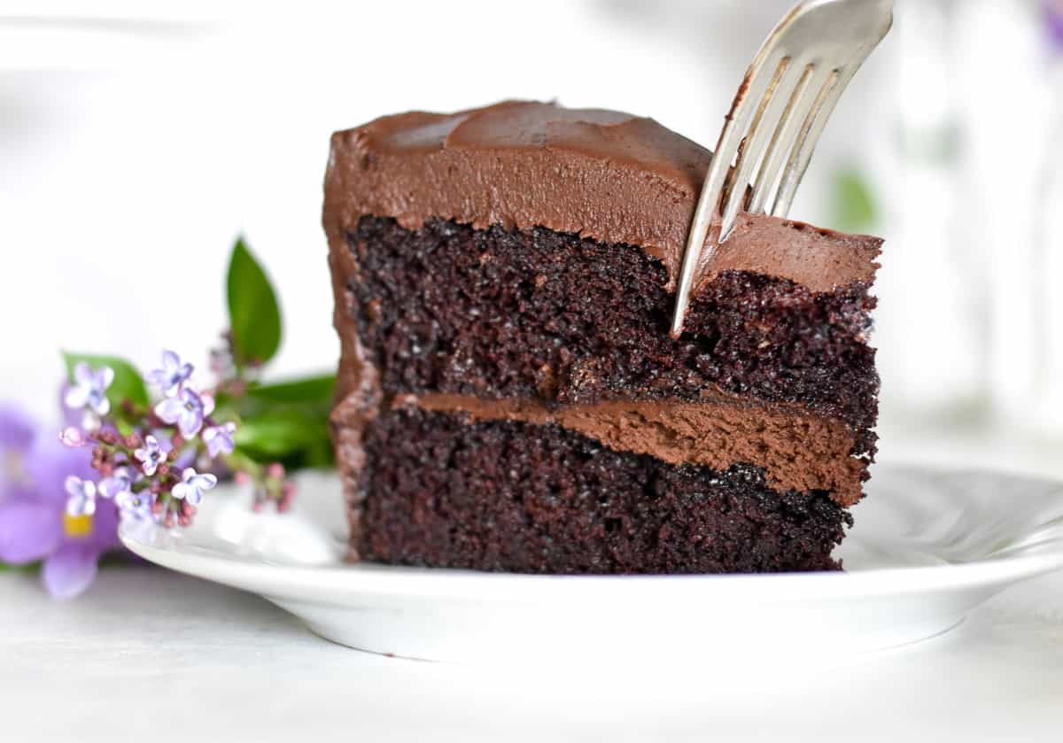 Slice of chocolate cake with fork digging in.