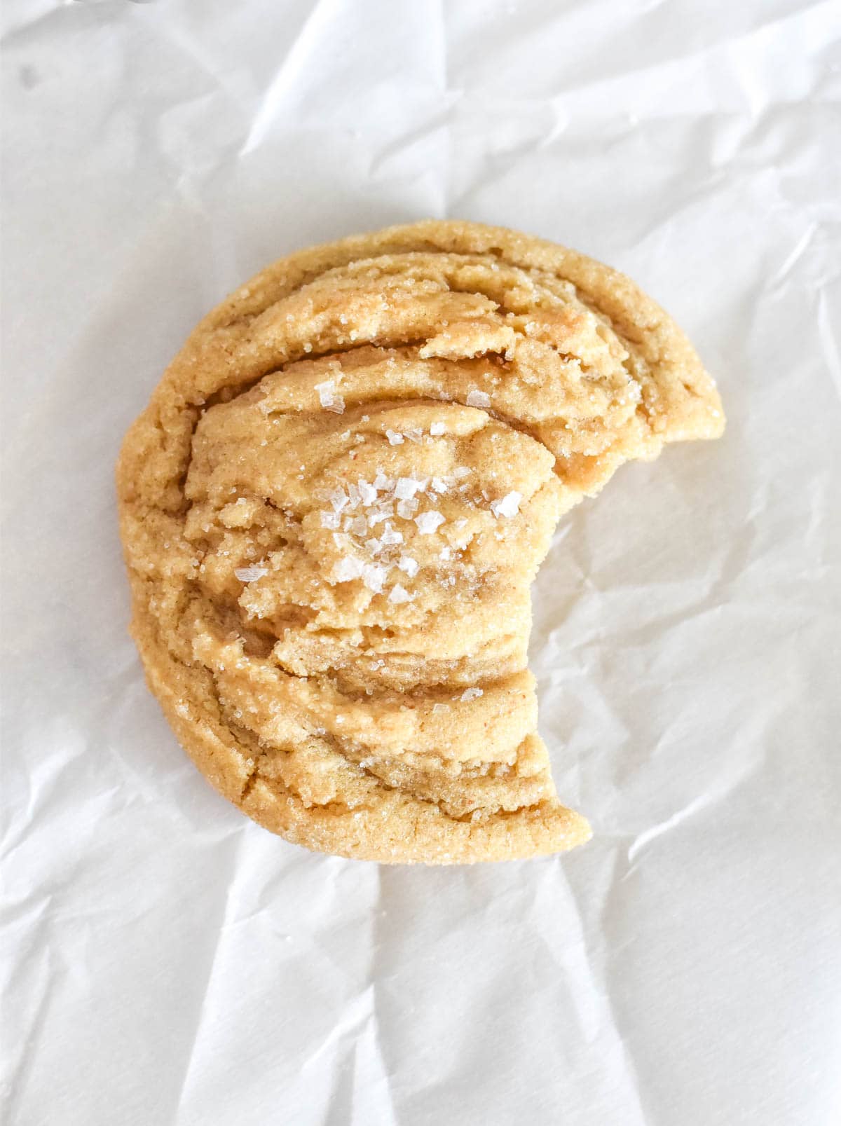 Close-up of salted honey cookie on white paper background.