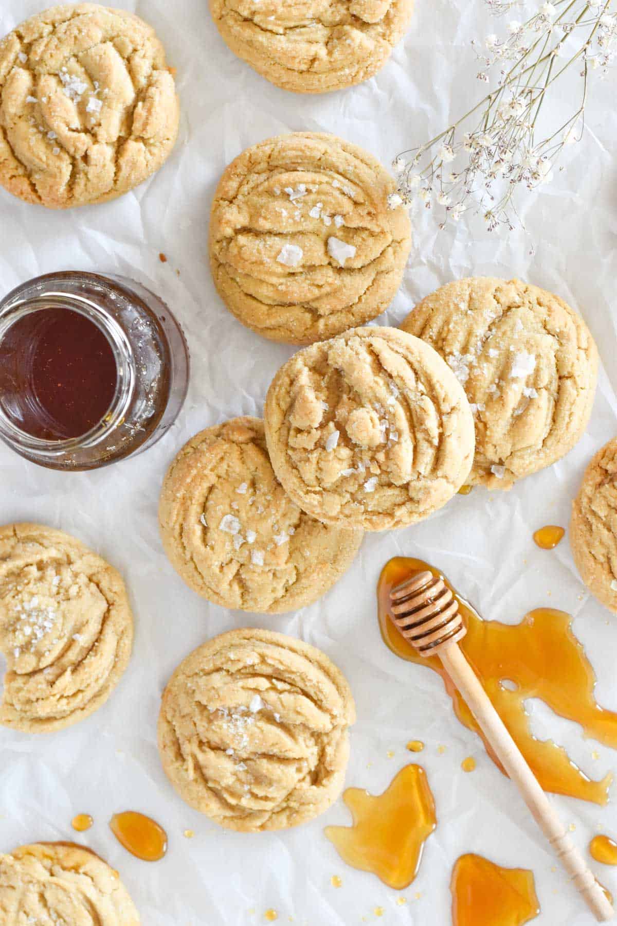 cookies on white parchment paper with honey drizzled around them.