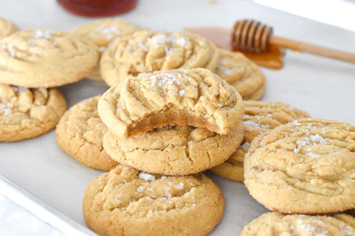 cookie with bite out of it stacked on pile of cookies.